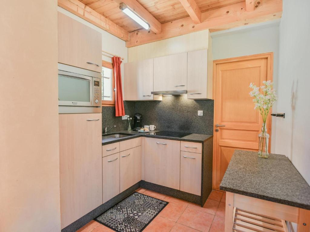 a kitchen with white cabinets and a vase of flowers at Lac Bleu Nr 38 in Lacapelle-Marival