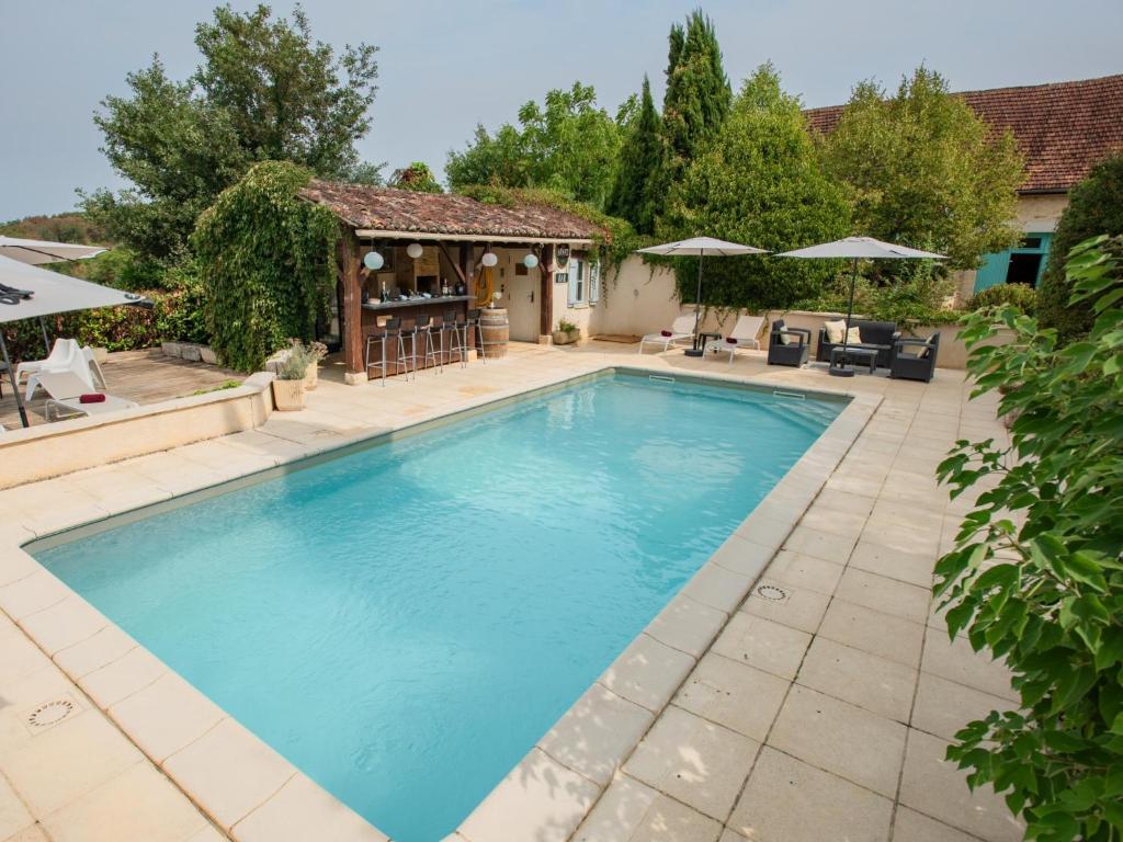 ein Swimmingpool im Garten mit einem Pavillon in der Unterkunft Tournesol in Dégagnac
