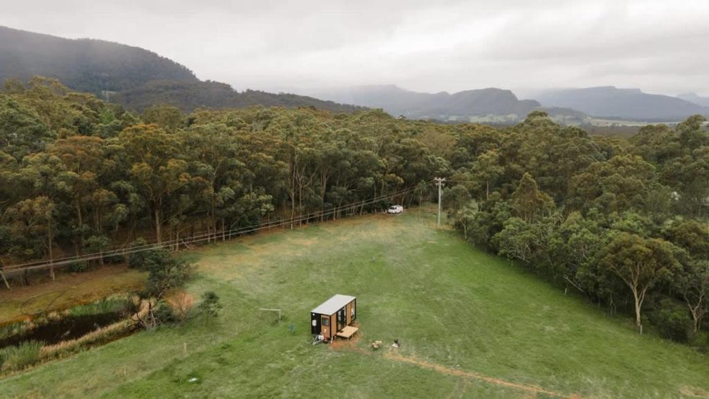 an aerial view of a field with a truck on it at Gumnut by Tiny Away in Kangaroo Valley