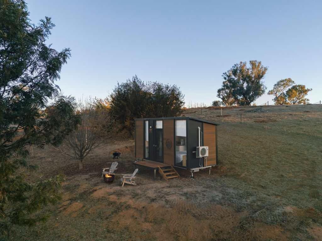 a tiny house sitting on top of a field at The High Country Views Escape by Tiny Away in Table Top