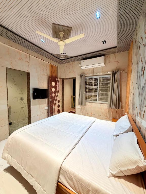 a large bed in a room with a ceiling at Saiprasad suite & stay in Ellora