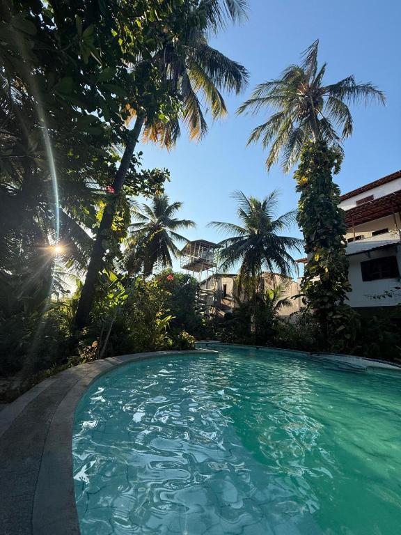 a swimming pool in a resort with palm trees at Estrela de Mundaú in Trairi