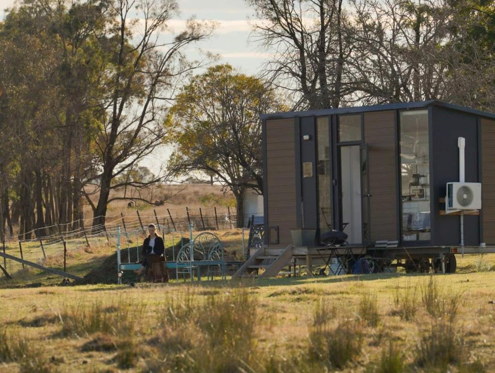 a man standing in front of a tiny house at Little Argyle Tiny House by Tiny Away in Coonabarabran