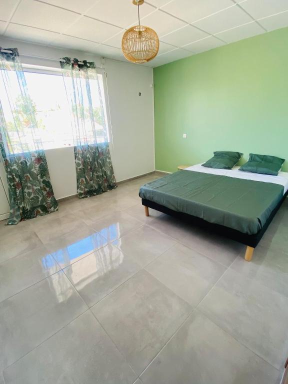 a bedroom with a bed in the middle of a room at Grand appartement ventilé in Morne-à-lʼEau