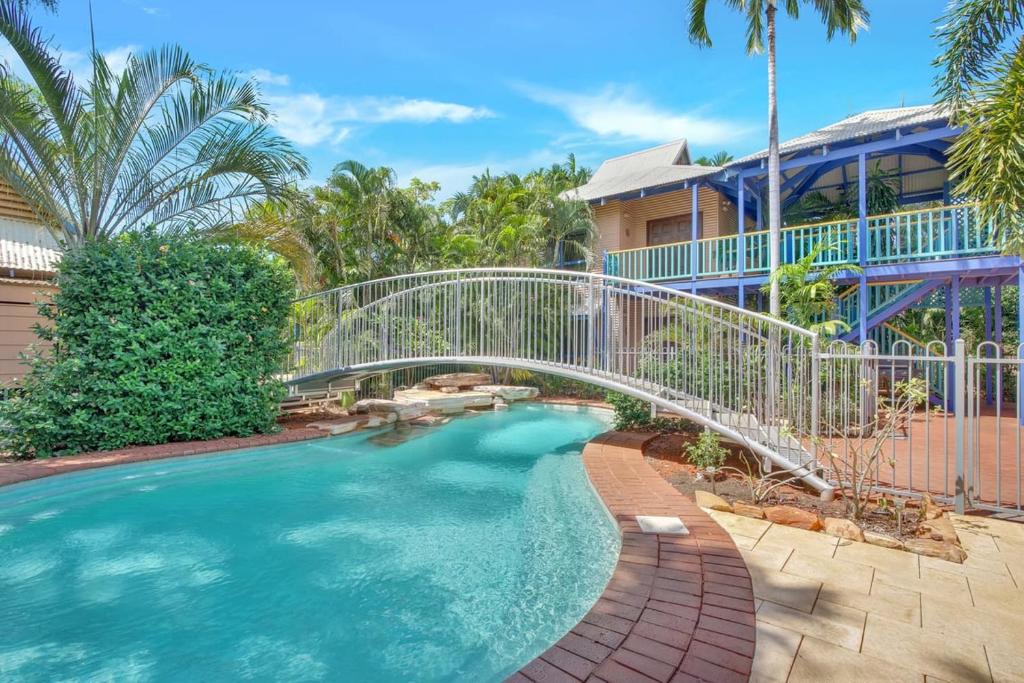 a bridge over a swimming pool with a house at The Zoo House in Broome