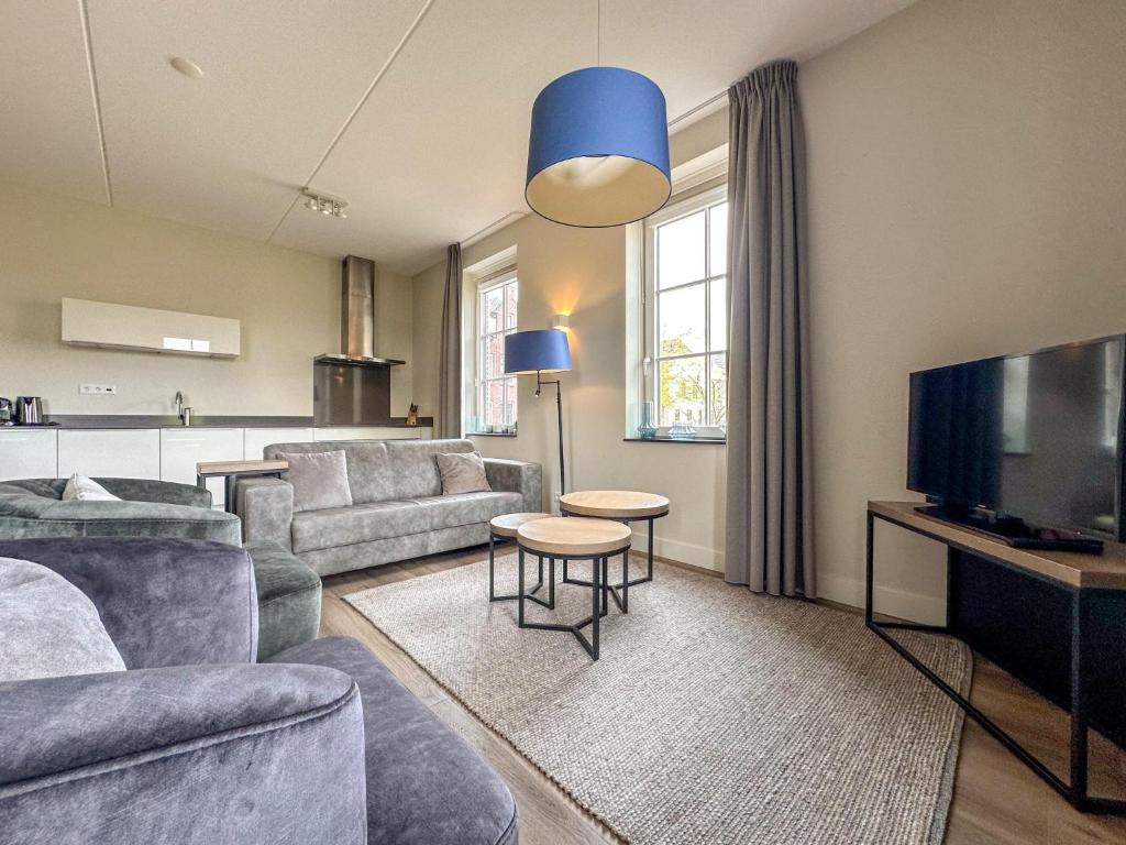 a living room with a couch and a tv at Garden de luxe 27B in Colijnsplaat