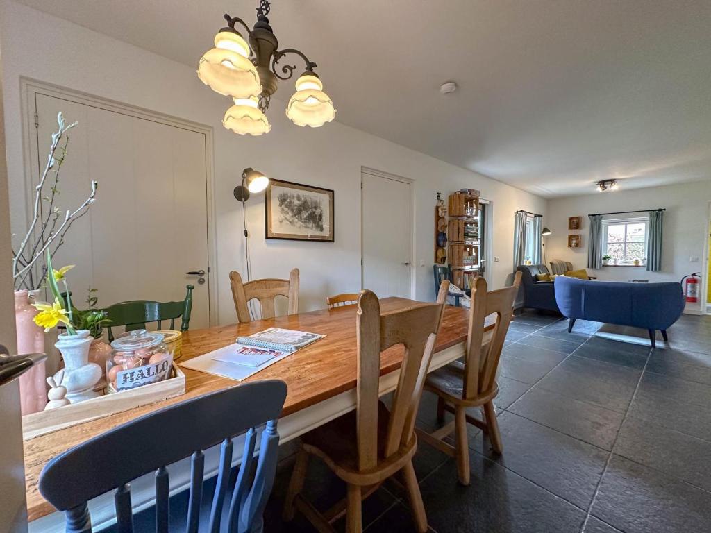 a dining room with a wooden table and chairs at Op de Beemd in Zeeland