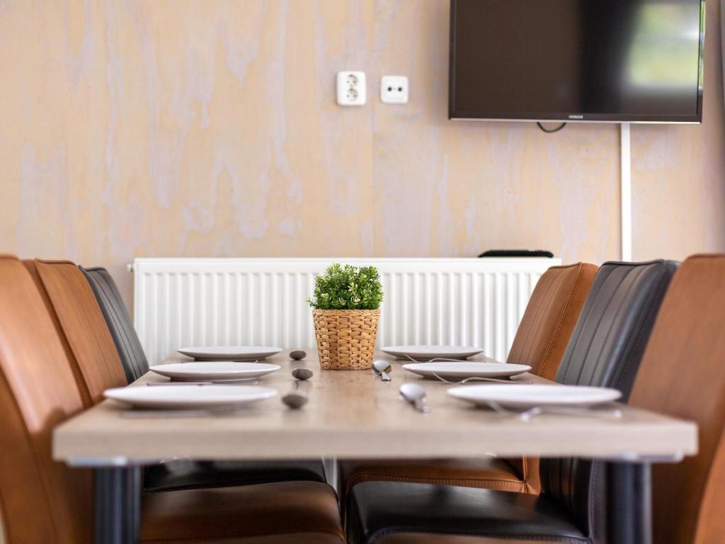 a table with chairs and a potted plant on it at Woodlodge XL 588 in Vessem
