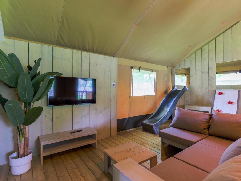 a living room with a couch and a slide at Safaritent 7 in Vessem