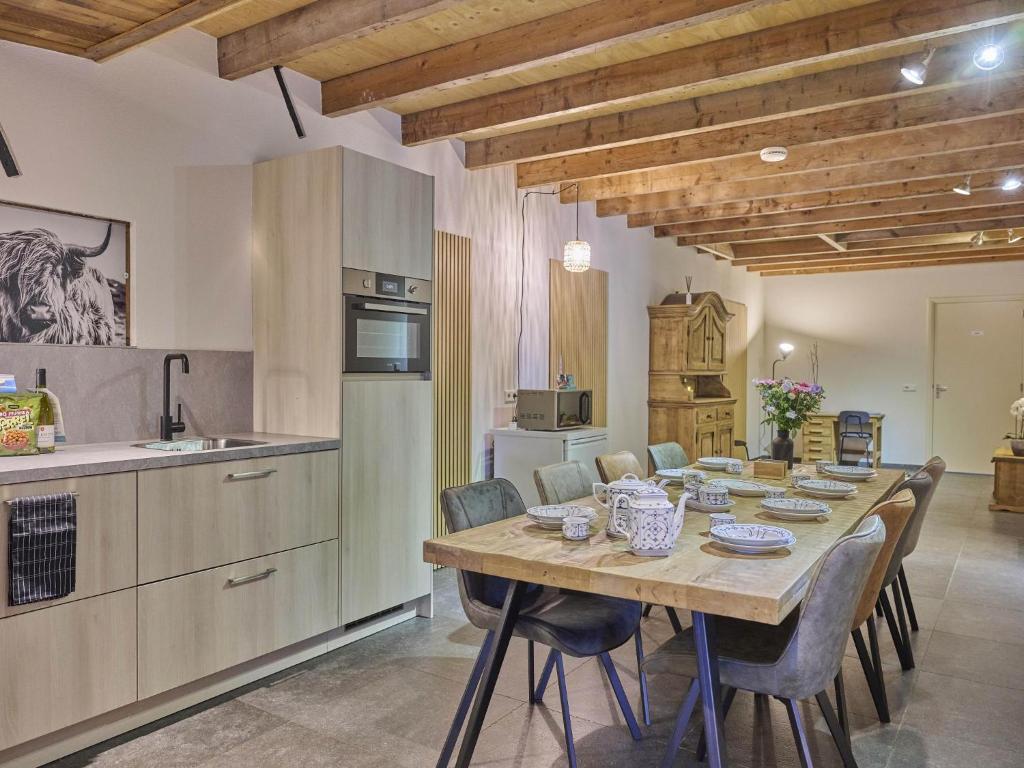 a kitchen and dining room with a table and chairs at De Rouwenbogt in Reusel