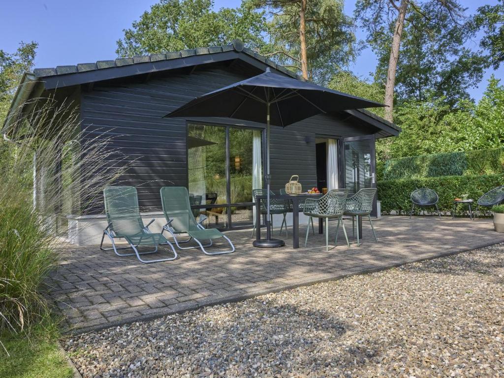 a patio with a table and chairs and an umbrella at Quercus in Valkenswaard