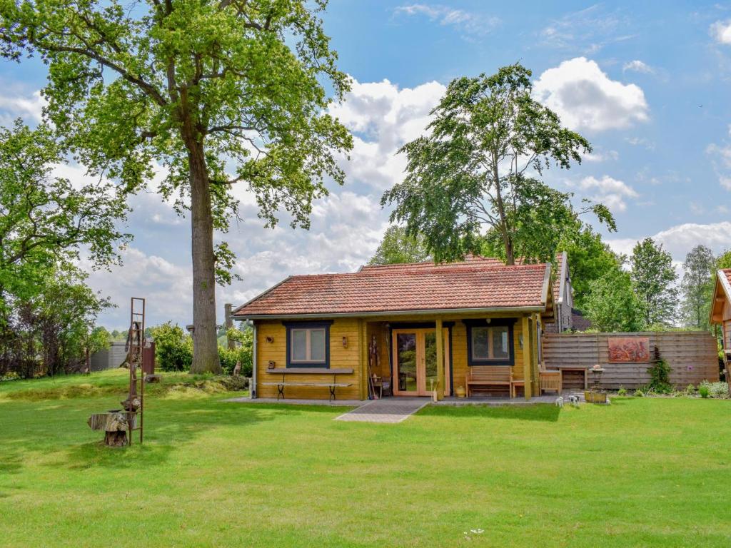a small yellow house in a field of grass at Onder de oude Eik in Lottum