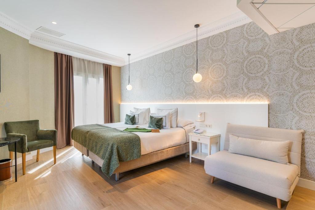 a hotel room with a bed and a chair at Meliá Plaza Valencia in Valencia