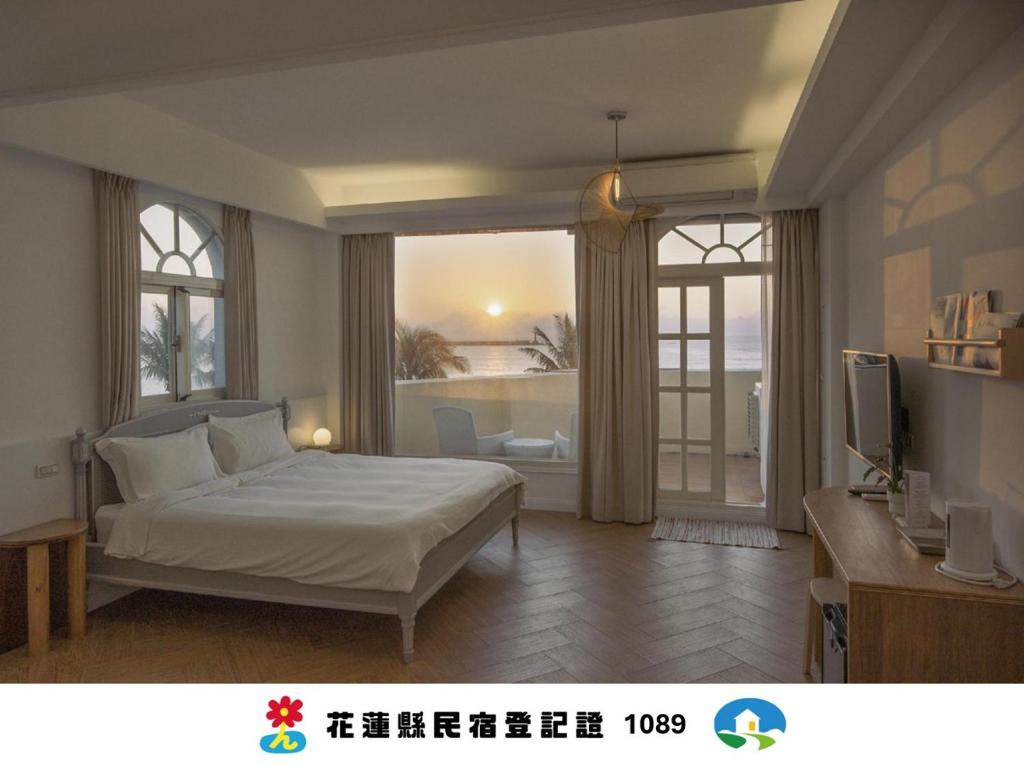 a bedroom with a bed and a large window at OwlStay The Salt in Hualien City