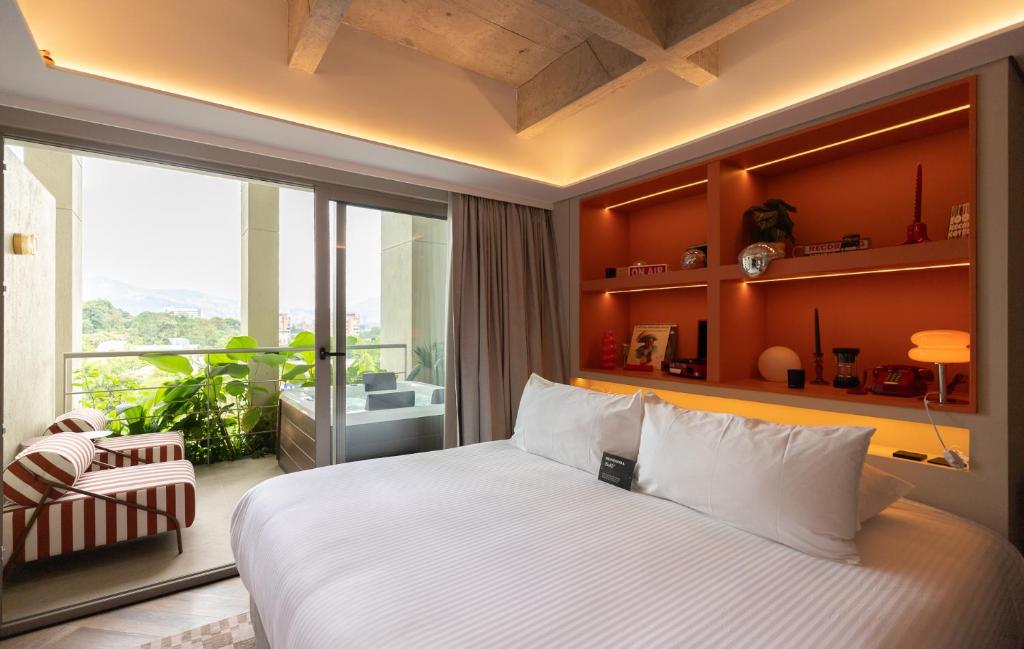 a bedroom with a large bed and a large window at BoH Collection in Medellín