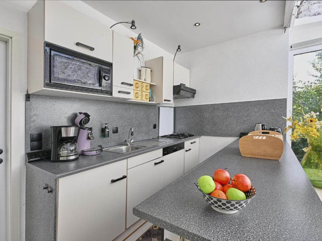 a kitchen with a bowl of fruit on a counter at Aan de oever in Stevensweert