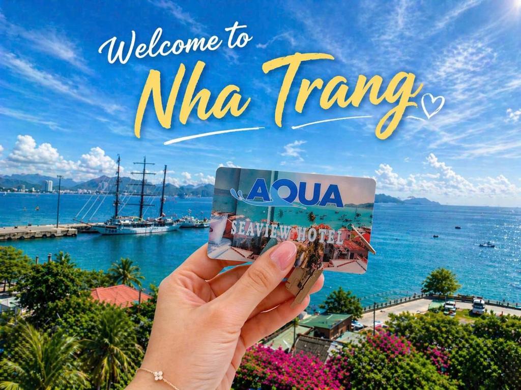a hand holding up a picture of the ocean at AQUA Seaview Hotel in Nha Trang