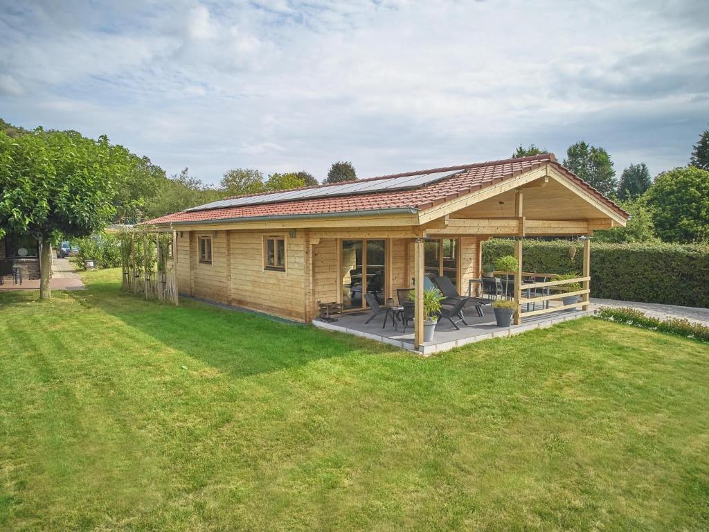 a small house with a large deck in a yard at Bie Leentje op de wei in Schinnen