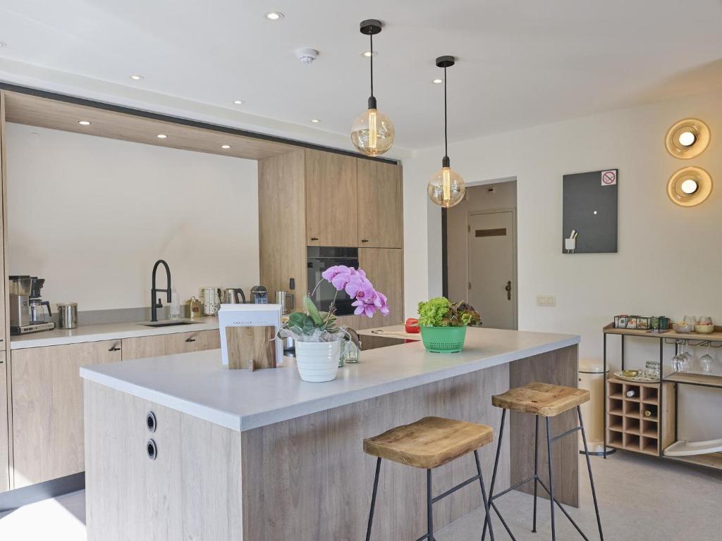 a kitchen with a large island with two bar stools at Silt in Schinnen