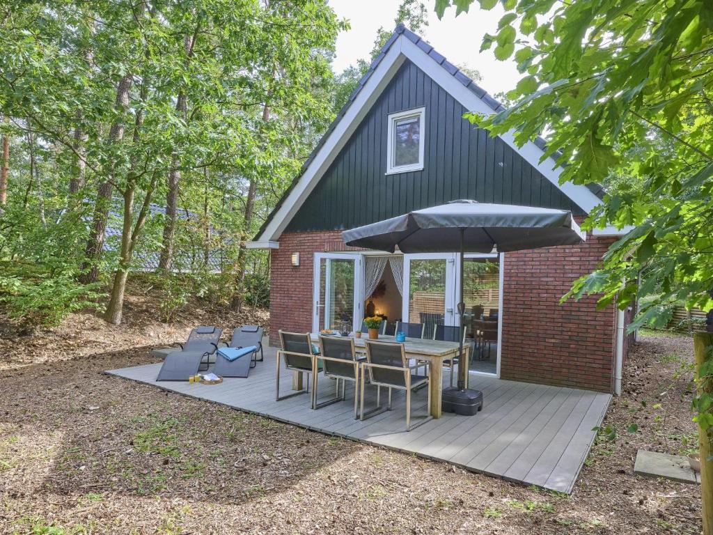 a patio with a table and chairs and an umbrella at De Linde in Nunspeet
