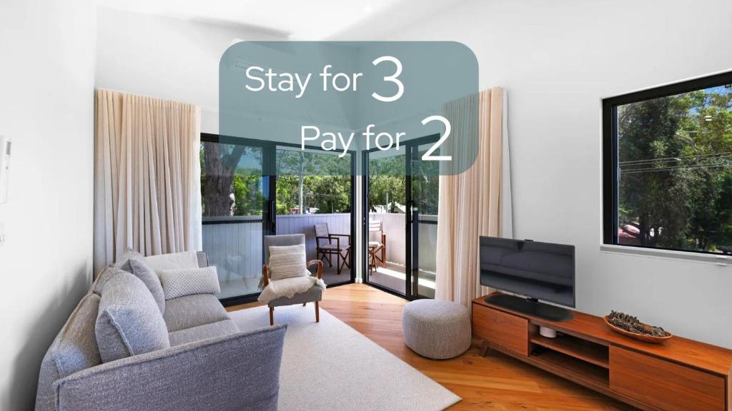 a living room with a couch and a tv at Ti Willa by Book Jervis Bay - Elevated Escape in Huskisson in Huskisson