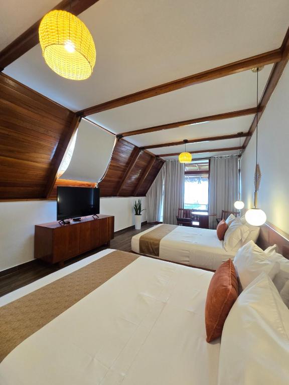 a hotel room with two beds and a television at Riosol Laguna Azul in Sauce