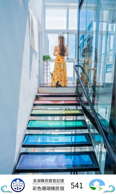 a woman is walking down a stair case at Color Coral Boutique Hotel in Magong