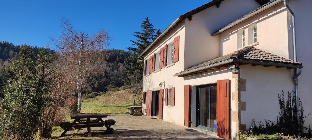 a building with a picnic table in front of it at Balcon des fées in Le Malzieu-Ville