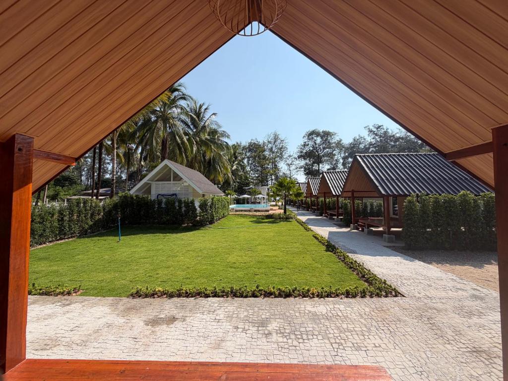 a view of a garden from a pavilion at Ther lay beach resort in Sikao
