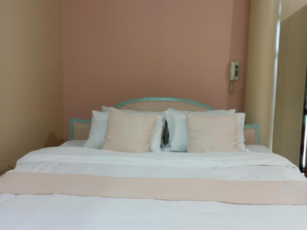 a white bed with white pillows in a room at Verde Royale Resort in Calasiao