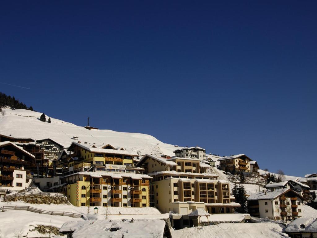 
snow covered mountains in front of a house at Hotel Garni Alpenjuwel in Serfaus
