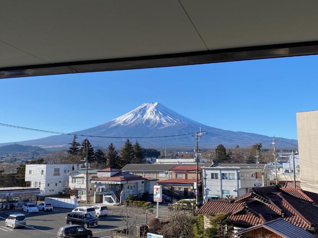 a view of a snow covered mountain from a city at Guest House KURA 776 Mt Fuji View and 1 min to Gekkoji Station in Fujiyoshida