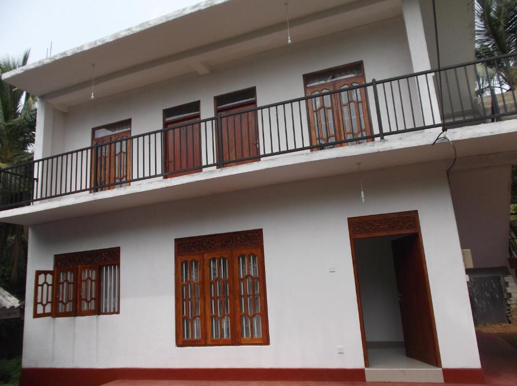 a house with a balcony on the top of it at Sumudu Villa in Hikkaduwa