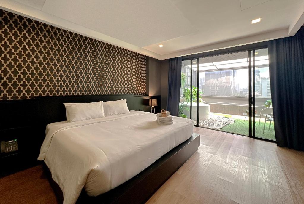 a bedroom with a large bed and a large window at G Boutique Silom Hotel in Bangkok