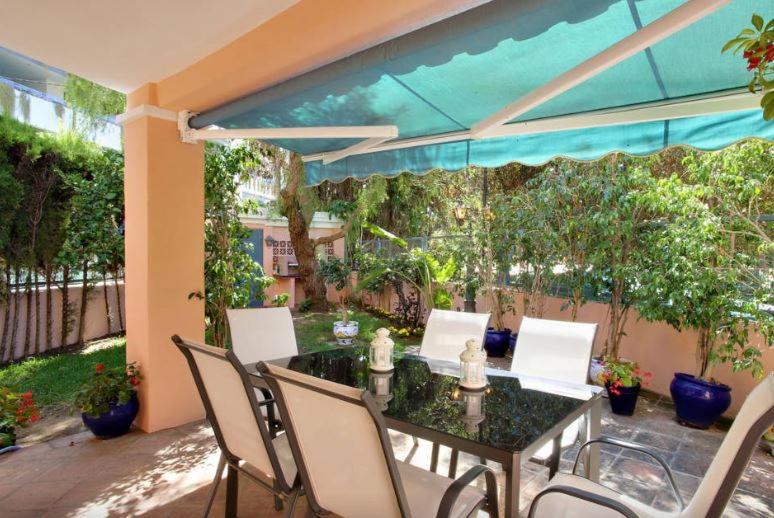 un patio con mesa y sillas en Casa El Capricho, en Marbella
