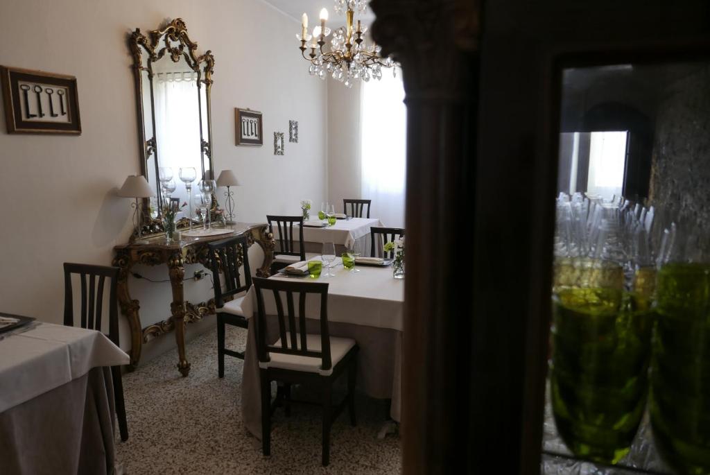 een eetkamer met tafels en stoelen en een kroonluchter bij Agriturismo Boschi Celati in Roncaglia