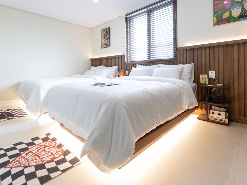 a bedroom with a large bed with white sheets at 호텔 도토리 in Gunsan-si