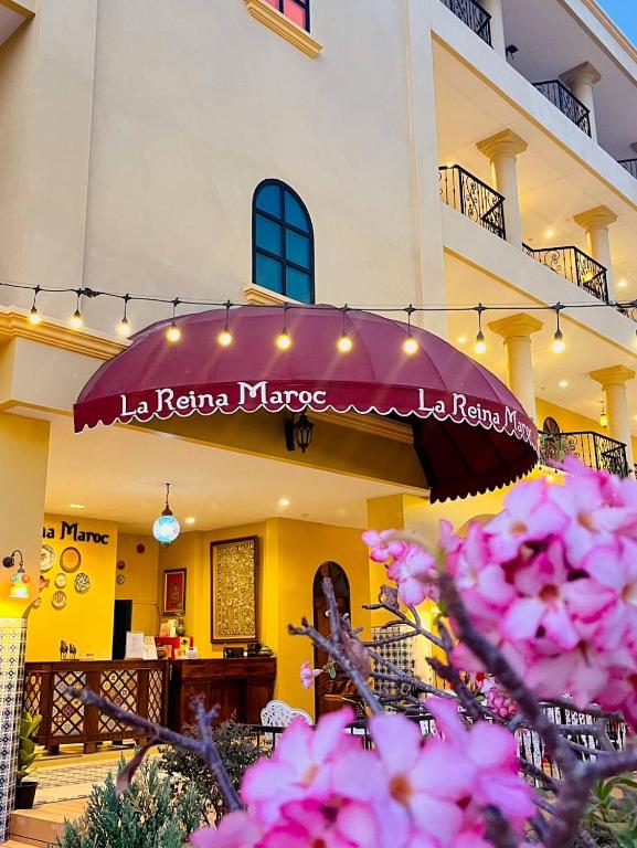 a building with a purple umbrella and some pink flowers at La Reina Maroc Hotel ปากช่อง เขาใหญ่ in Pak Chong