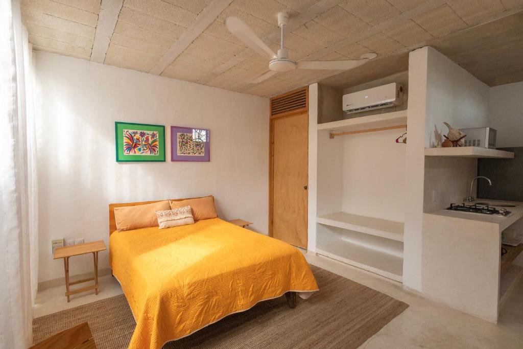 a bedroom with a bed with a yellow blanket at Las Guayas, depto Ceh in Progreso