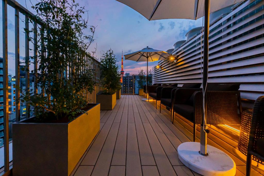 a balcony with benches and an umbrella on a building at Bay Hotel Tokyo Hamamatsucho in Tokyo