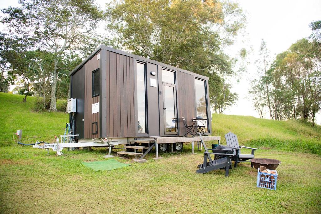 a tiny house sitting on top of a field at Tiny Inja 2 by Tiny Away in Comleroy