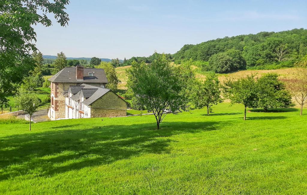 an old house in a field of green grass at Grange En Campagne in Vauxaillon