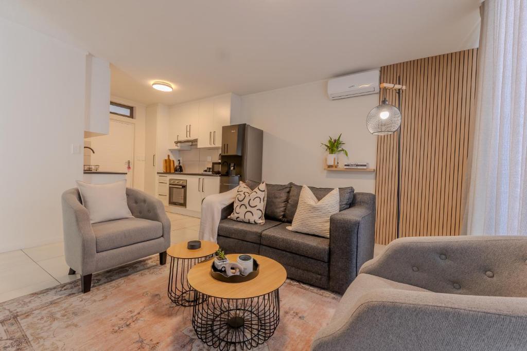 a living room with a couch and two chairs and a table at The Stay Edit Windhoek in Windhoek