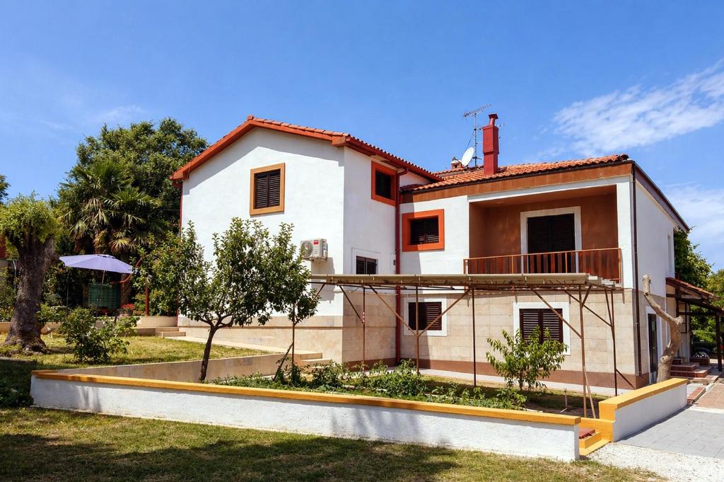 a house with a garden in front of it at Ina in Funtana
