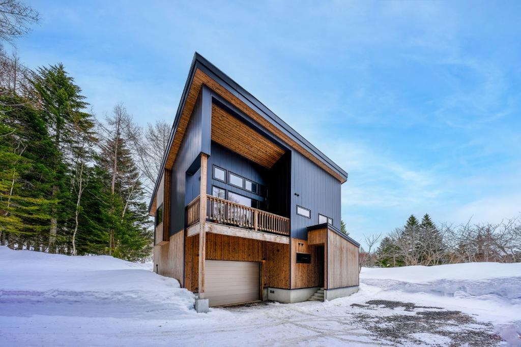 a house with a garage in the snow at COCO VILLA ニセコアンヌプリ-Niseko Annupuri in Rankoshi