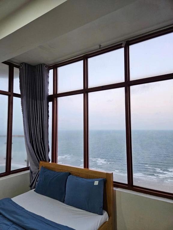 a bedroom with a view of the ocean through a window at ZoZo House - Homestay Bai Sau - bien Vung Tau in Vung Tau