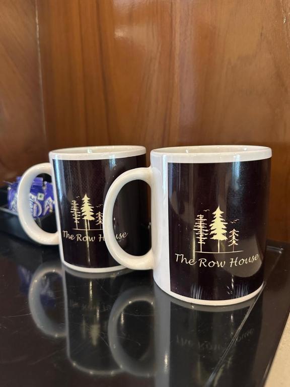 two coffee mugs sitting on top of a table at The Row House Kasauli in Kasauli