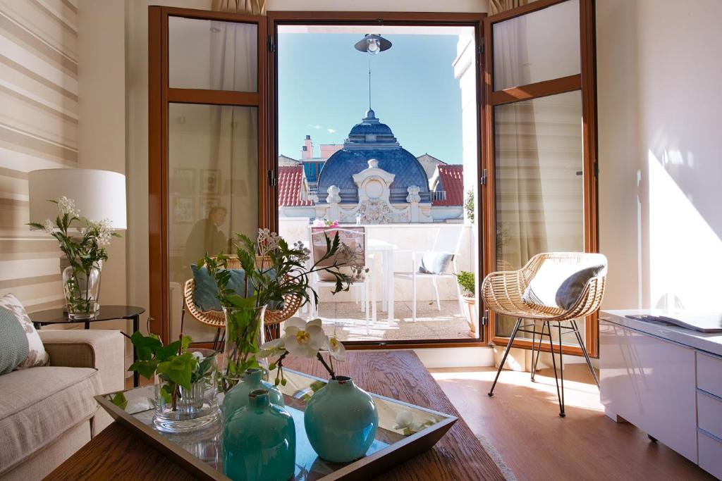 a living room with a table with vases on it at iloftmalaga Ático Alameda Principal in Málaga