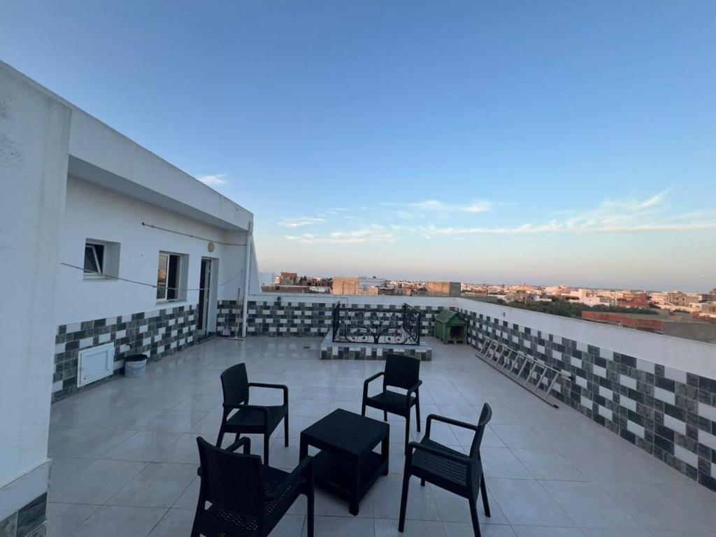 a balcony with chairs and tables on a building at Studio de vacance à louer in Monastir