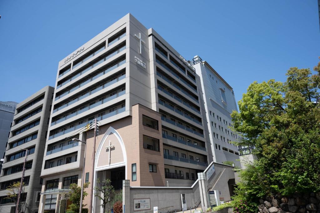 a tall building with a church in front of it at Hotel the Lutheran in Osaka